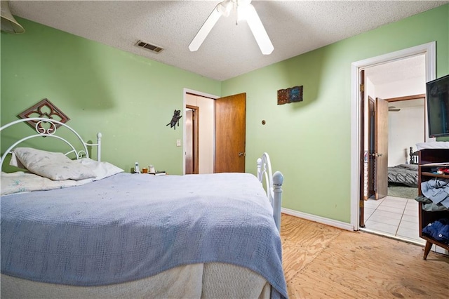 8170 Wilmer Georgetown Rd, Wilmer, AL 36587 - bedroom featuring a textured ceiling, a ceiling fan, visible vents, wood finished floors, and baseboards