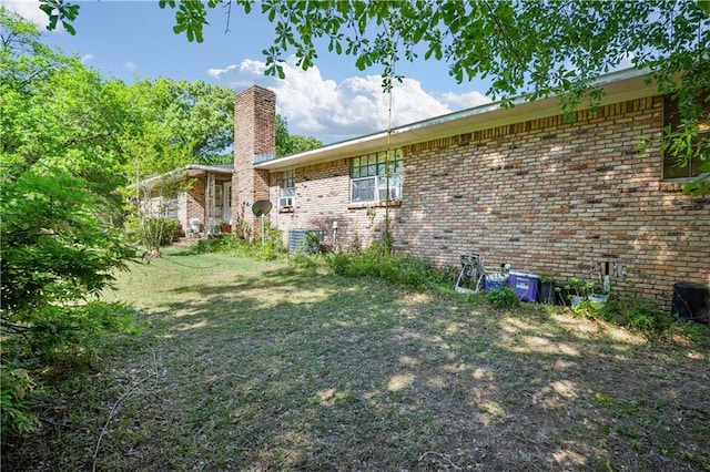 8170 Wilmer Georgetown Rd, Wilmer, AL 36587 - view of home's exterior featuring a yard, central AC, brick siding, and a chimney