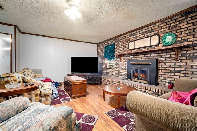 8170 Wilmer Georgetown Rd, Wilmer, AL 36587 - living room featuring crown molding, wood finished floors, a fireplace, and a textured ceiling