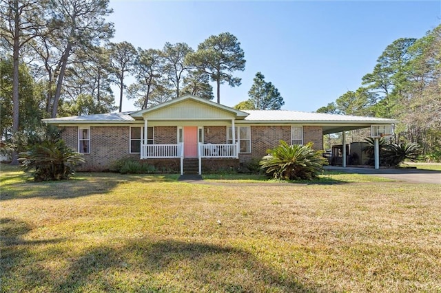 view of front of property with covered porch, brick siding, driveway, a carport, and a front yard