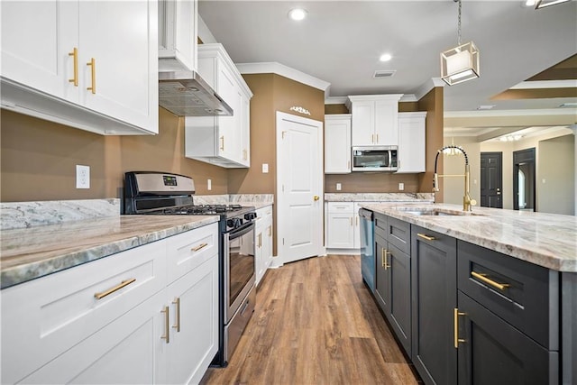 kitchen with sink, appliances with stainless steel finishes, white cabinets, and decorative light fixtures