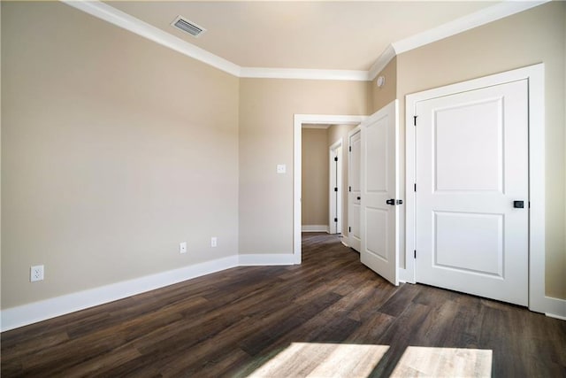 empty room featuring ornamental molding and dark wood-type flooring