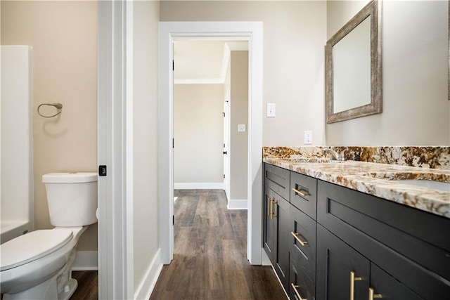 bathroom with toilet, vanity, and hardwood / wood-style floors