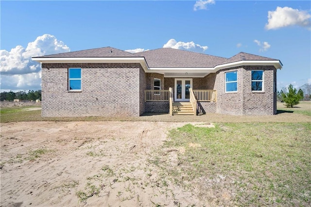 rear view of property featuring a yard and french doors