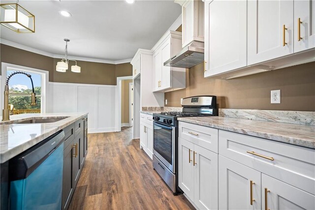 kitchen with hanging light fixtures, stainless steel appliances, light stone countertops, white cabinets, and sink