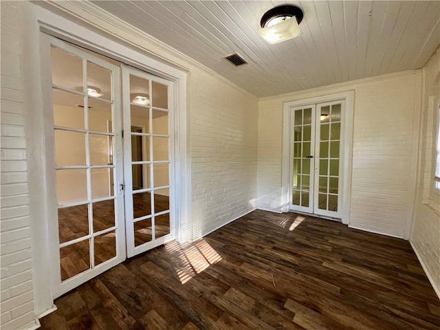 interior space with wood ceiling, crown molding, dark wood-type flooring, french doors, and brick wall