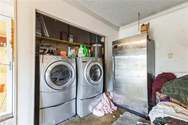 washroom with laundry area, washing machine and dryer, a textured ceiling, and ornamental molding