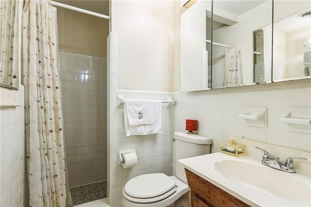 full bath with a tile shower, toilet, tile walls, and vanity