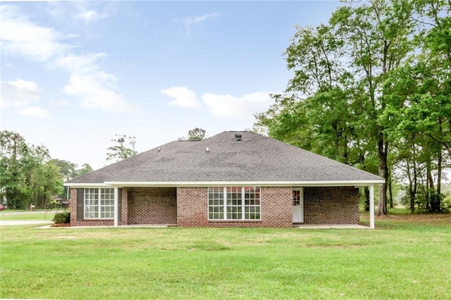 back of house with brick siding and a lawn