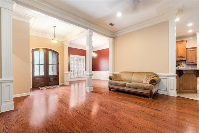 living room featuring hardwood / wood-style flooring, french doors, and ornate columns