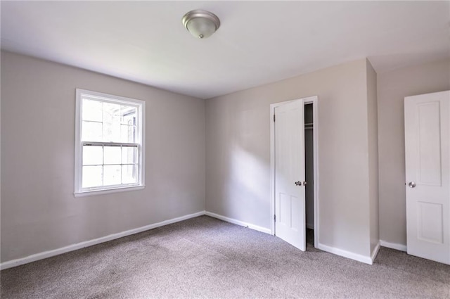 unfurnished bedroom featuring carpet and a closet