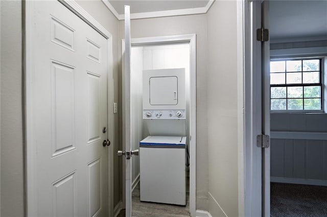 laundry area with stacked washing maching and dryer and carpet