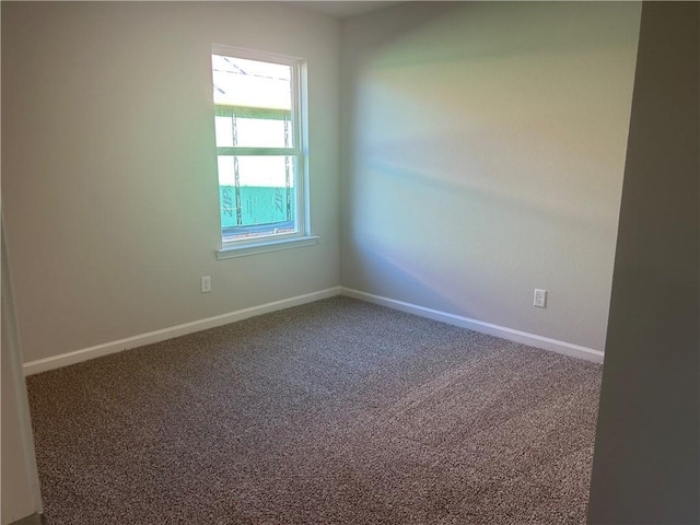 carpeted spare room featuring baseboards