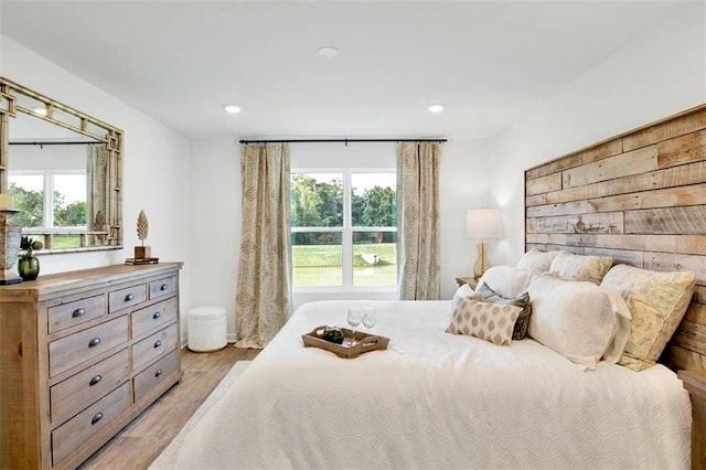 bedroom with multiple windows and light wood-type flooring