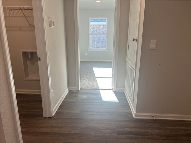 corridor with baseboards and dark wood-style flooring