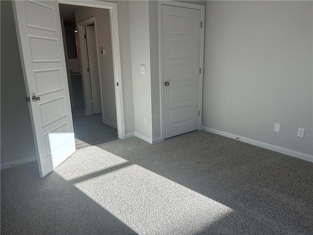 unfurnished bedroom with carpet flooring and baseboards