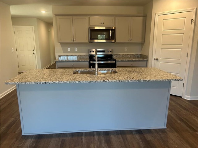 kitchen with stainless steel appliances, light stone countertops, dark wood finished floors, and baseboards