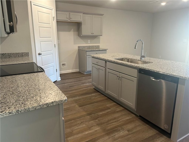 kitchen featuring gray cabinets, stainless steel dishwasher, dark wood-type flooring, and a sink