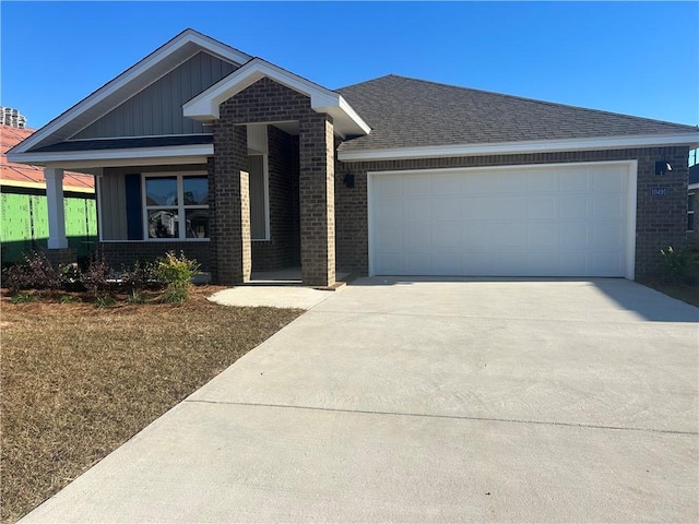 view of front of house featuring concrete driveway, board and batten siding, roof with shingles, an attached garage, and brick siding