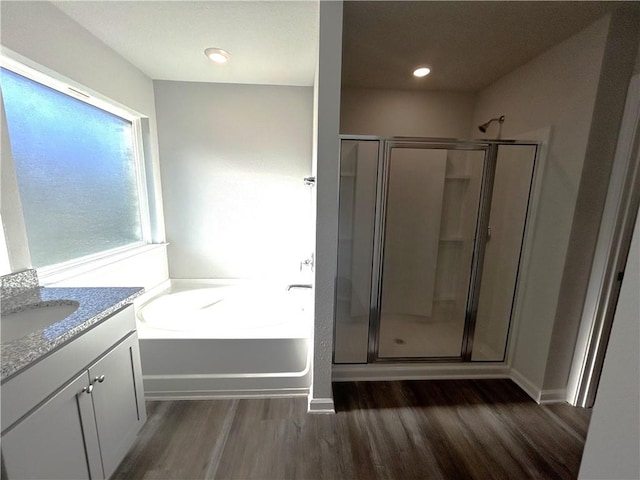 bathroom with vanity, wood-type flooring, and shower with separate bathtub