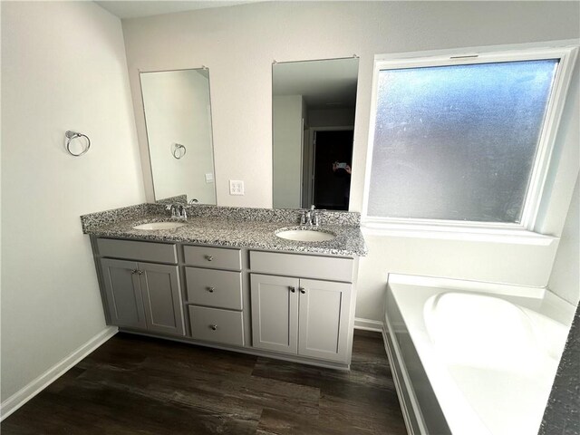 bathroom with vanity, hardwood / wood-style floors, and a bathtub