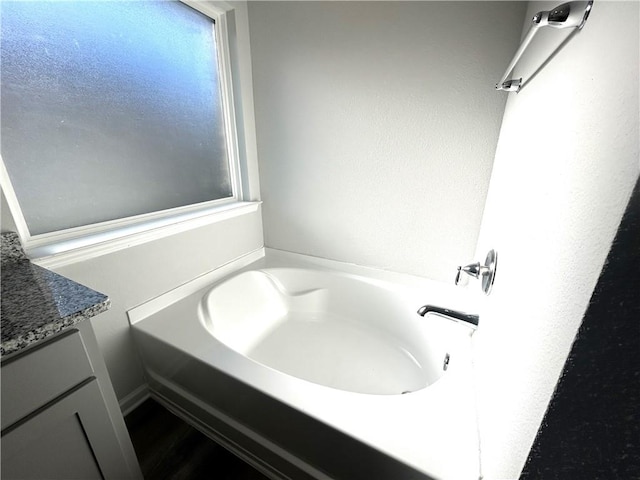 bathroom with vanity and a washtub