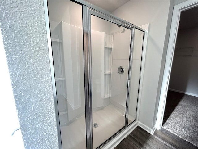 bathroom featuring hardwood / wood-style flooring and walk in shower