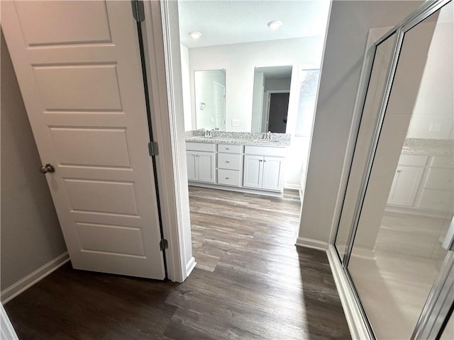 bathroom with vanity, an enclosed shower, and hardwood / wood-style flooring