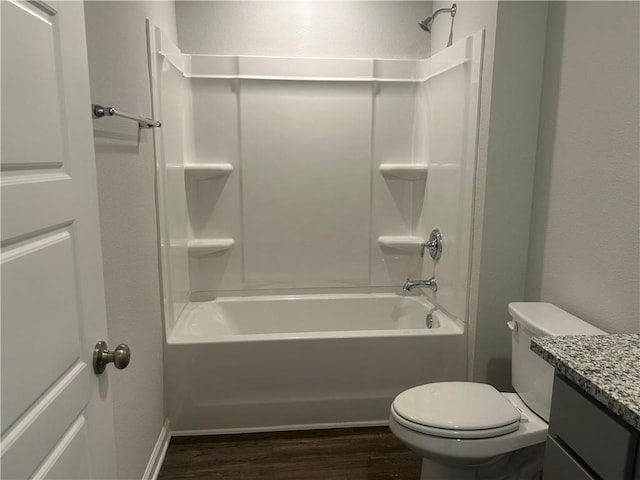 bathroom with wood finished floors, toilet, washtub / shower combination, and vanity