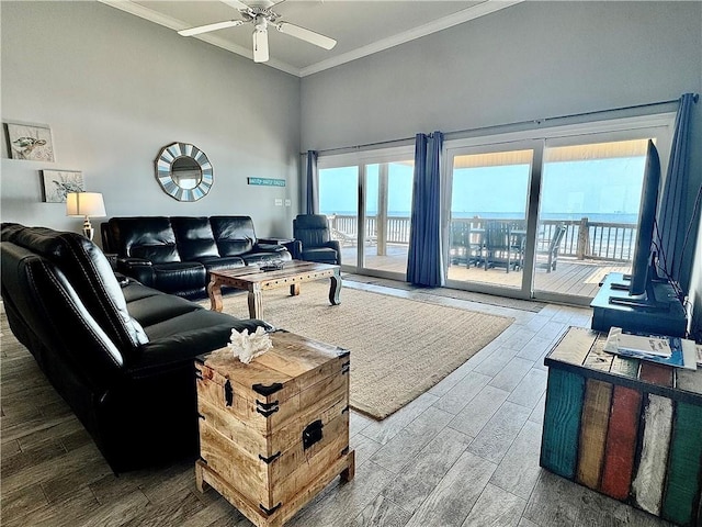 living room with a ceiling fan, crown molding, and wood finished floors