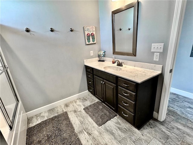 bathroom with baseboards, vanity, and wood tiled floor