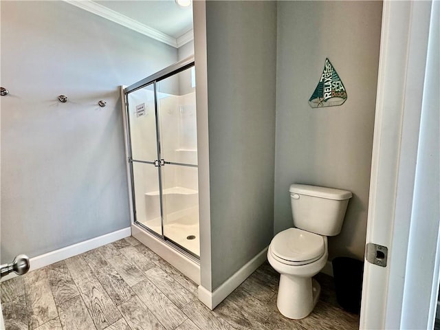 full bathroom with toilet, ornamental molding, a shower stall, baseboards, and wood tiled floor