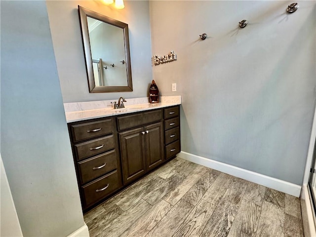 bathroom featuring vanity, baseboards, and wood finished floors