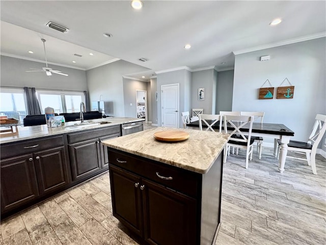 kitchen with visible vents, wood tiled floor, stainless steel dishwasher, and a center island