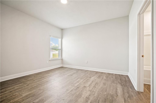 empty room featuring wood finished floors and baseboards