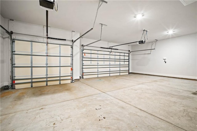 garage with baseboards and a garage door opener
