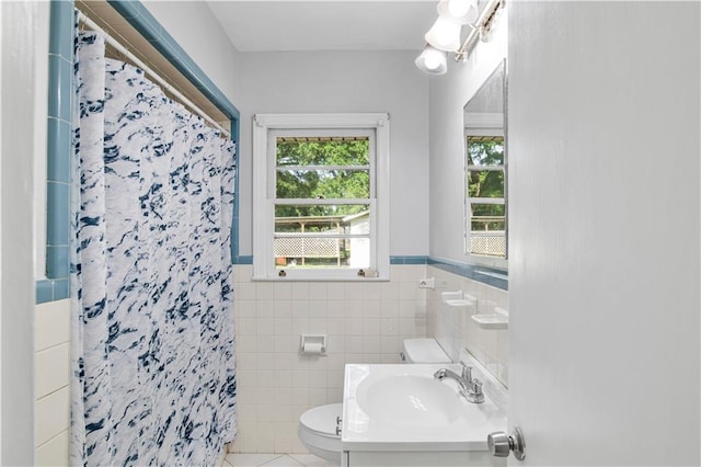 1215 Anchor Dr, Mobile, AL 36693 - bathroom featuring tile walls, toilet, a shower with curtain, tile patterned floors, and a wainscoted wall