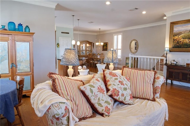 living room featuring dark hardwood / wood-style flooring, an inviting chandelier, and crown molding