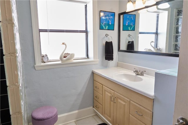 bathroom with vanity with extensive cabinet space, tile flooring, and plenty of natural light