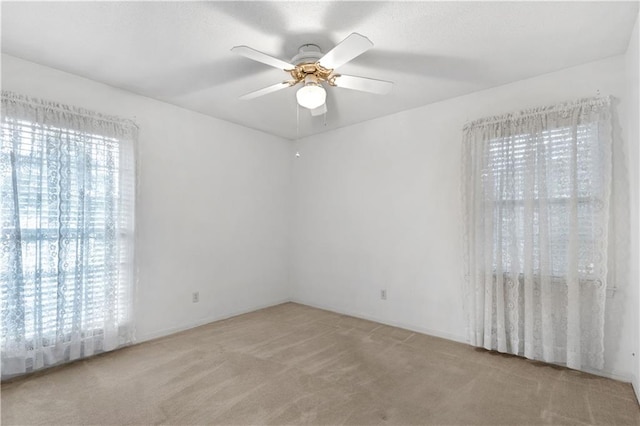 unfurnished room with light colored carpet and ceiling fan