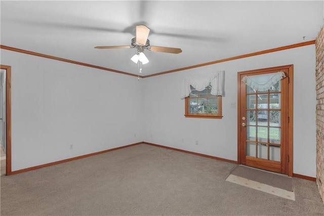 carpeted spare room featuring ceiling fan and crown molding