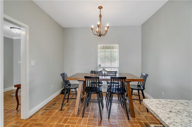 dining area with crown molding and a chandelier