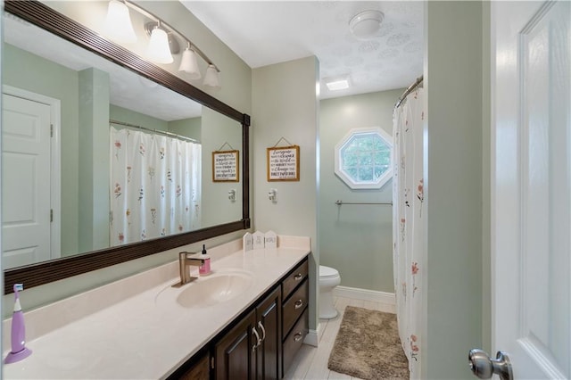 bathroom featuring tile patterned flooring, vanity, and toilet