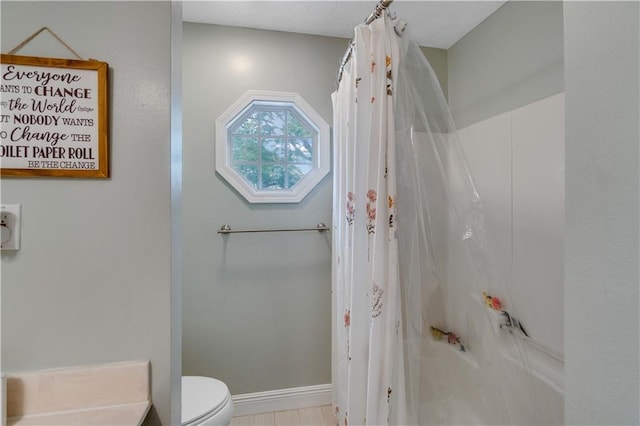 bathroom with shower / bath combination with curtain and toilet