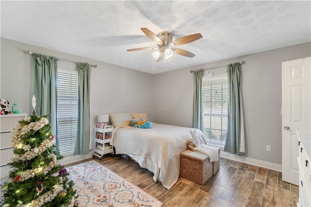 bedroom featuring a textured ceiling, dark hardwood / wood-style floors, and ceiling fan