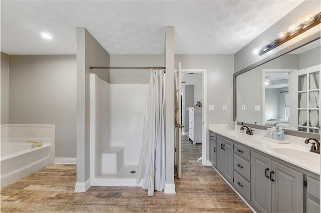 bathroom featuring hardwood / wood-style flooring, vanity, a textured ceiling, and independent shower and bath