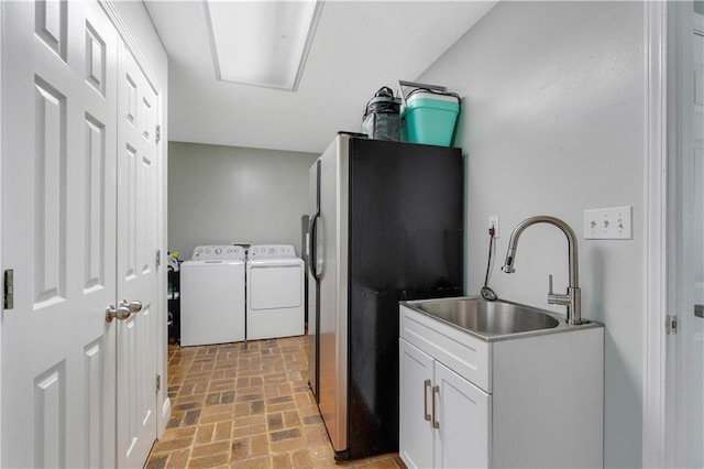 laundry room featuring washer and dryer, cabinets, and sink