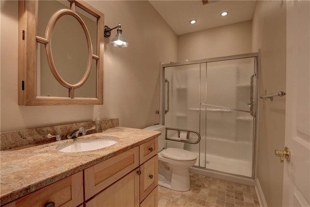 bathroom with vanity, toilet, and a shower with door