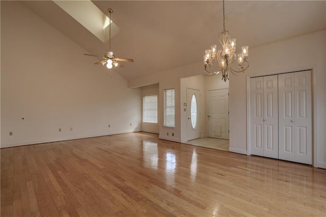 entryway featuring high vaulted ceiling, ceiling fan with notable chandelier, and light wood-type flooring