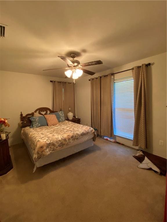 bedroom featuring carpet flooring, a ceiling fan, and visible vents